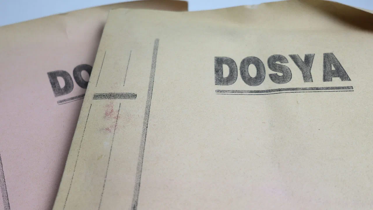 Two old document folders stacked on a plain surface